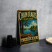 A vintage-style metal sign for Chain of Lakes State Park, featuring a canoe and a scenic landscape, is displayed on a gray countertop next to some black camera lenses.