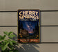 A vintage-style sign for Cherry Springs State Park in Pennsylvania, featuring a night sky scene with stars and a silhouetted pine tree.