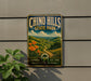 A vintage-style metal sign for Chino Hills State Park, featuring a scenic landscape with a winding path and orange flowers.