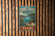 A vintage-style metal sign for Choke Canyon State Park in Texas, featuring a scenic landscape with a lake, mountains, and cacti.