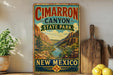 A vintage-style metal sign for Cimarron Canyon State Park in New Mexico, featuring a scenic illustration of the canyon landscape.