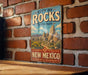 A vintage metal sign for the City of Rocks State Park in New Mexico, featuring a scenic illustration of the park's landscape.
