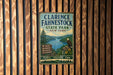 A vintage metal sign for Clarence Fahnestock State Park in New York, featuring a scenic image of a lake surrounded by mountains and a bird in flight.