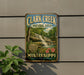 A vintage-style metal sign for Clark Creek Natural Area in Mississippi, featuring a waterfall and lush greenery.