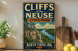 A vintage-style sign for Cliffs of the Neuse State Park in North Carolina, featuring a scenic landscape with a river and cliffs.