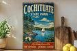 A vintage-style sign for Cochitiate State Park, featuring a scenic image of a sailboat on a lake surrounded by pine trees.