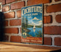 A vintage metal sign for Cochitiate State Park, featuring a scenic illustration of a lake with a sailboat, surrounded by trees and mountains.