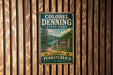 A vintage metal sign for Colonel Denning State Park in Pennsylvania, featuring a scenic landscape with a lake and mountains.