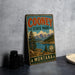 A vintage-style sign for Cooney State Park in Montana, featuring a scenic landscape with mountains, trees, and a lake.