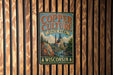 A vintage-style metal sign for Copper Culture State Park in Wisconsin, featuring a scenic illustration of a mining operation and a waterfall.