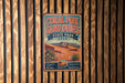 A vintage-style metal sign for the Coral Pink Sand Dunes State Park in Utah, featuring a desert landscape with mountains in the background.
