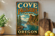 a vintage-style sign for Cove Palisades State Park in Oregon, with a scenic mountain landscape and a river in the background.