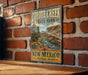 A vintage-style metal sign for Coyote Creek State Park in New Mexico, featuring a scenic landscape with a river and mountains.
