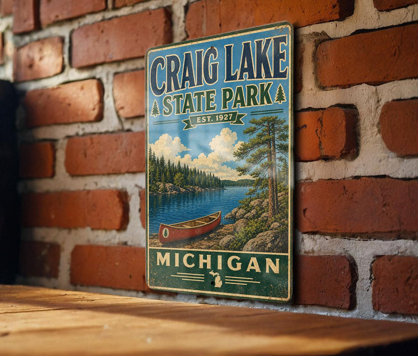 A vintage metal sign for Craig Lake State Park in Michigan, featuring a scenic illustration of a lake, canoe, and forest.