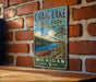 A vintage metal sign for Craig Lake State Park in Michigan, featuring a scenic illustration of a lake, canoe, and forest.
