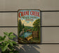 A vintage-style metal sign for Crane Creek State Park in Ohio, featuring a scenic landscape with a lake, trees, and a bird.