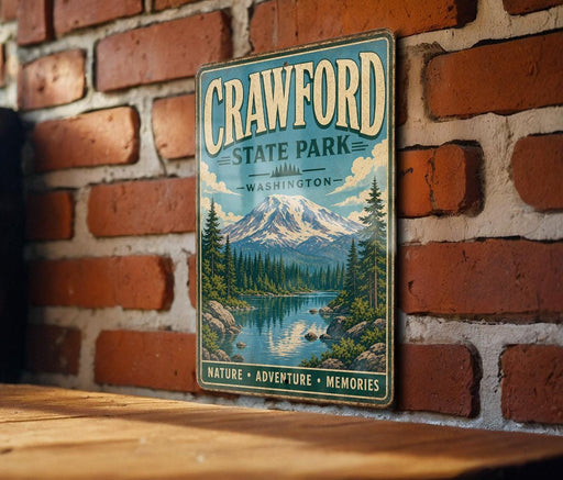 A vintage metal sign for Crawford State Park in Washington, featuring a scenic mountain landscape with a lake and pine trees.