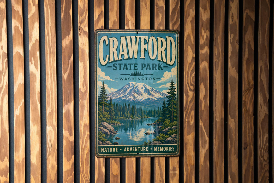 A metal sign for Crawford State Park in Washington, featuring a scenic mountain landscape with a river and pine trees.