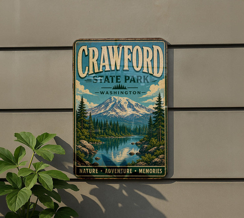 A vintage metal sign for Crawford State Park in Washington, featuring a scenic mountain landscape with pine trees, a lake, and a waterfall.