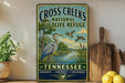 A vintage-style sign for the Cross Creek National Wildlife Refuge in Tennessee, featuring an illustration of a heron and ducks in a natural setting.