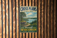 A vintage metal sign for Cross Plains State Park in Wisconsin, featuring a scenic landscape with a lake and mountains.