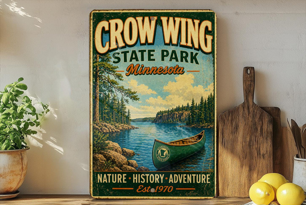 A vintage-style sign for Crow Wing State Park in Minnesota, featuring a canoe on a lake surrounded by pine trees.
