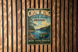 A vintage metal sign for Crow Wing State Park in Minnesota, featuring a canoe and a scenic landscape.