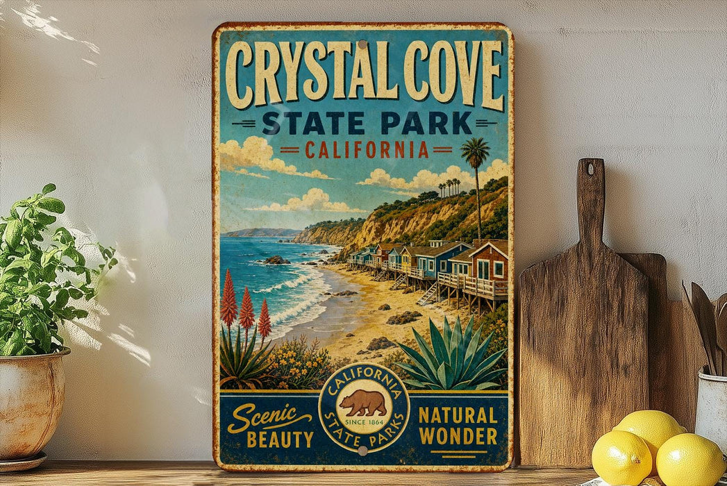 A vintage-style metal sign for Crystal Cove State Park, California, featuring a scenic beach landscape with palm trees, cacti, and a wooden pier.