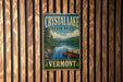 A vintage metal sign for Crystal Lake State Park in Vermont, featuring a scenic image of a lake and mountains.