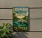 A vintage-style metal sign for Crystal River Preserve, featuring a manatee and palm trees, is displayed on a wall.