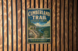 A vintage metal sign for Cumberland Trail State Park in Tennessee, featuring a scenic mountain landscape and a trail.