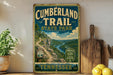 A vintage-style sign for the Cumberland Trail State Park in Tennessee, featuring a scenic mountain landscape with a winding trail.
