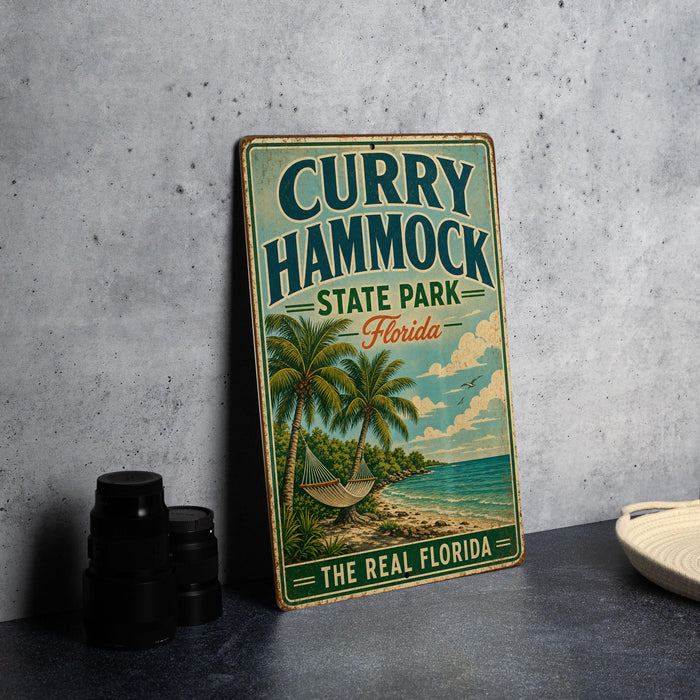 A vintage metal sign for "Curry Hammock State Park, Florida" is displayed on a gray wall, featuring a palm tree and beach scene.