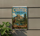 A vintage-style sign for Custer State Park, featuring a mountain landscape with a bighorn sheep in the foreground.