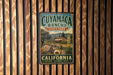 A vintage-style metal sign for Cuymac Ranch State Park in California, featuring a scenic illustration of the park's landscape.
