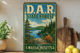 A vintage-style metal sign for the State Forest in Massachusetts, featuring a scenic landscape with pine trees, a lake, and mountains.