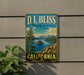 A vintage-style sign for D.L. Bliss State Park in California, featuring a scenic landscape with mountains, a lake, and pine trees.