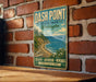 A vintage metal sign for Dash Point State Park in Washington, featuring a scenic landscape with a mountain, ocean, and coastal path.