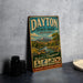A vintage metal sign for Dayton State Park, Nevada, featuring an illustration of a scenic landscape with mountains, trees, and a river.