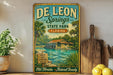 A vintage-style sign for De Leon Springs State Park in Florida, featuring a tropical landscape with palm trees, a house, and a body of water.