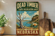 A vintage-style sign for Dead Timber State Recreation Area in Nebraska, featuring a scenic landscape with a lake and mountains.