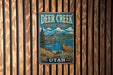 A vintage metal sign for Deer Creek State Park in Utah, featuring a scenic landscape with mountains, a lake, and a deer.