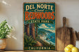A vintage-style sign for Del Norte Coast Redwoods State Park in California, featuring a scenic illustration of the park's landscape.
