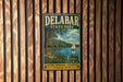 A vintage metal sign for Delabar State Park, featuring a scenic illustration of a lake, trees, and a sailboat, mounted on a wooden wall.