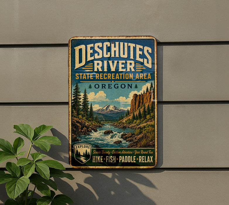 A vintage-style metal sign for Deschutes River State Recreation Area in Oregon, featuring a scenic landscape with a river, mountains, and pine trees.