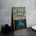 A vintage-style metal sign for Detroit Lake, Oregon, featuring a scenic landscape with a lake, mountains, and pine trees.