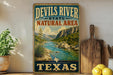 A vintage-style sign for the Devils River State Natural Area in Texas, featuring a scenic landscape with a river, mountains, and desert vegetation.