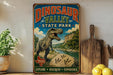 A vintage-style sign for Dinosaur Valley State Park, featuring a large illustration of a T-Rex dinosaur in a natural landscape.