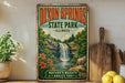 A vintage-style sign for Dixon Springs State Park in Illinois, featuring a waterfall and lush greenery, is displayed on a shelf next to a wooden cutting board and some potted plants.