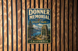a vintage-style sign for Donner Memorial State Park in California, mounted on a wooden wall.